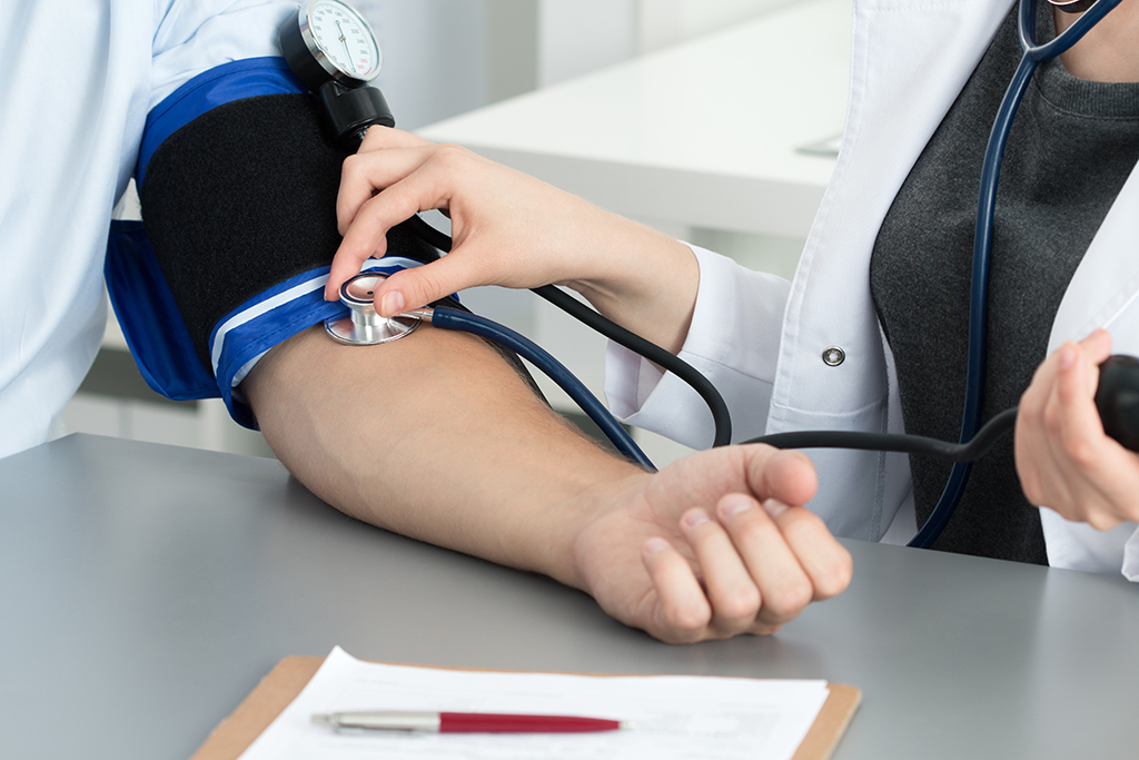 Female medicine doctor measuring blood pressure to her patient. Hands close up. Medical and healthcare concept